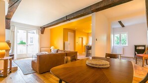 Un comedor con una mesa de madera, un sofá y una estantería.