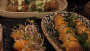 A table with various dishes, including a plate with rolled sushi and a bowl of salad. - Hotell MAVI (Viken)