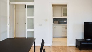 A modern apartment with a dining area, a kitchen, and a living room.