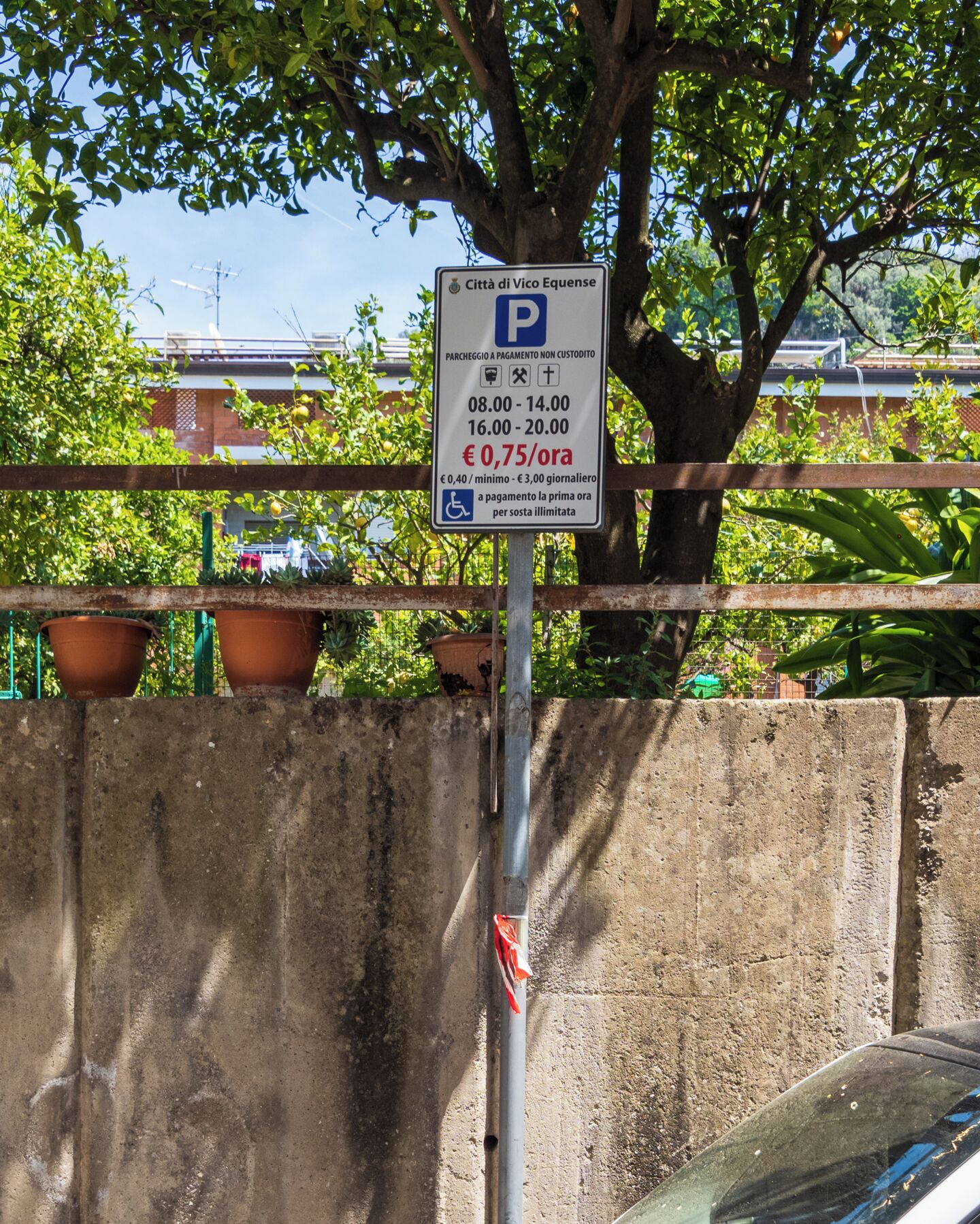 A parking sign with payment rates and hours.