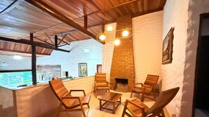 A cozy interior with wooden furniture, a fireplace, and a view through a large window.