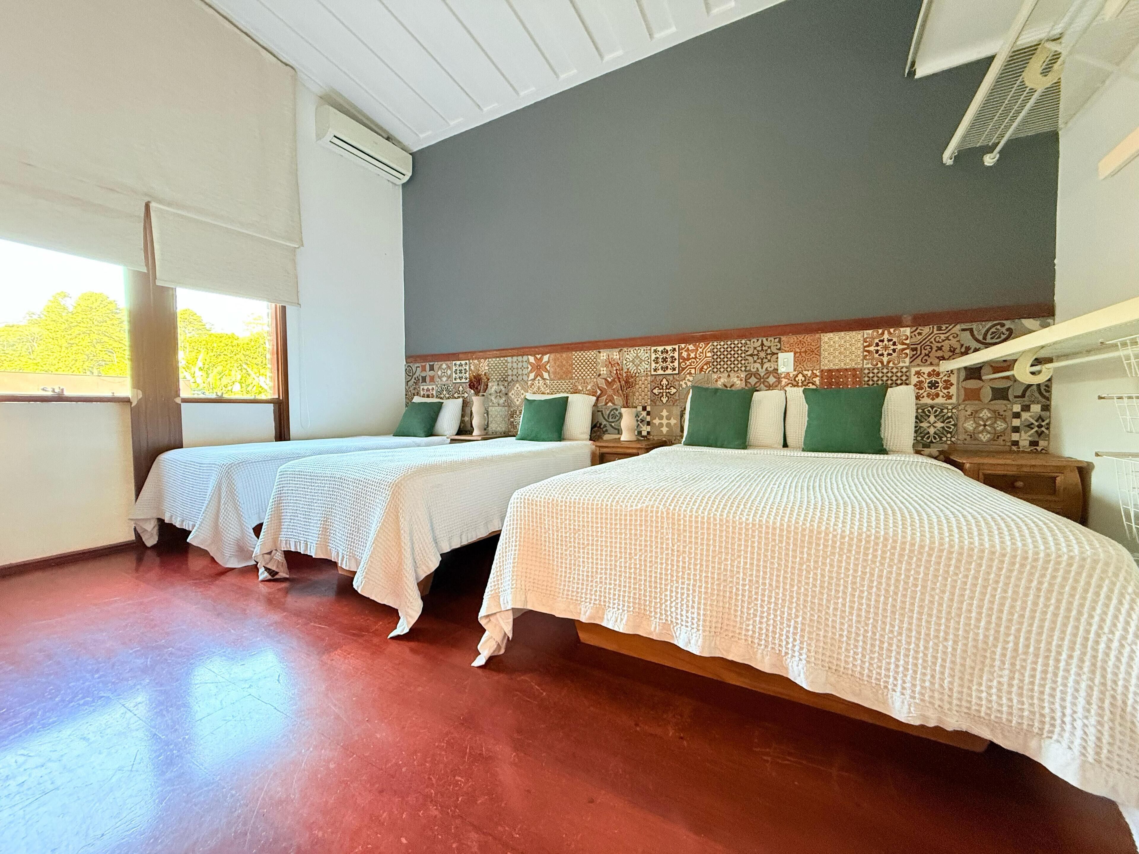 Una habitación con dos camas, un papel tapiz decorado y una ventana con vistas.