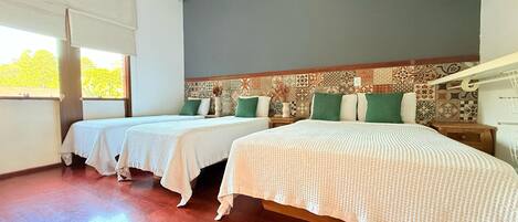 Una habitación con dos camas, un papel tapiz decorado y una ventana con vistas.