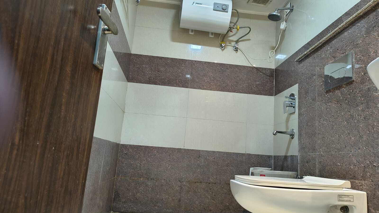 Un baño con inodoro, espejo y ducha.