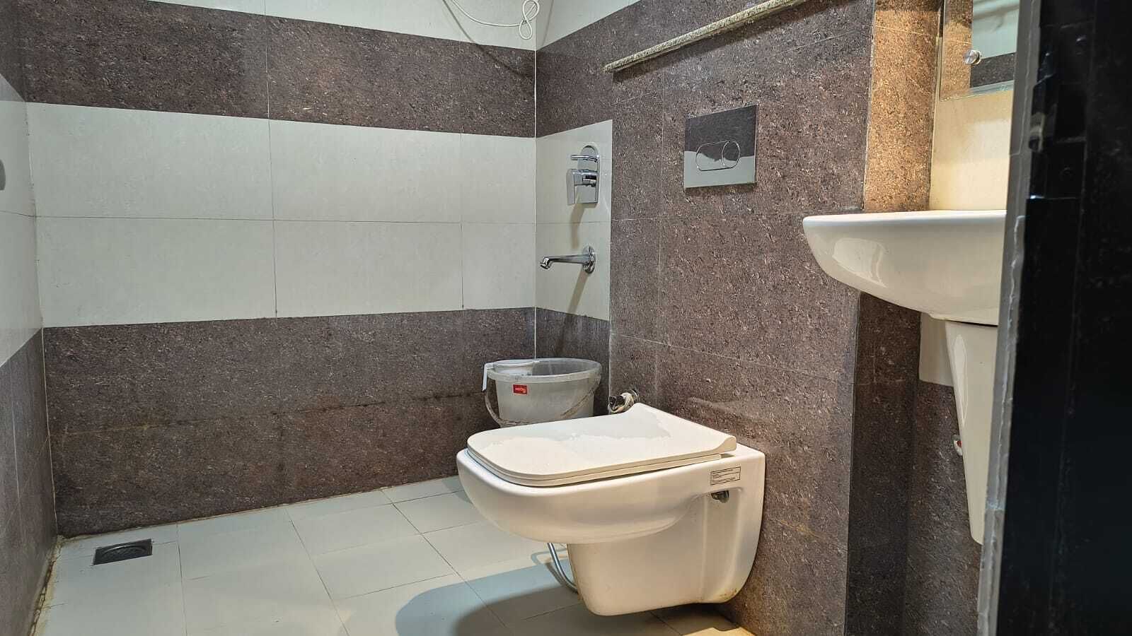 A small bathroom with a toilet, a sink, and a shower.