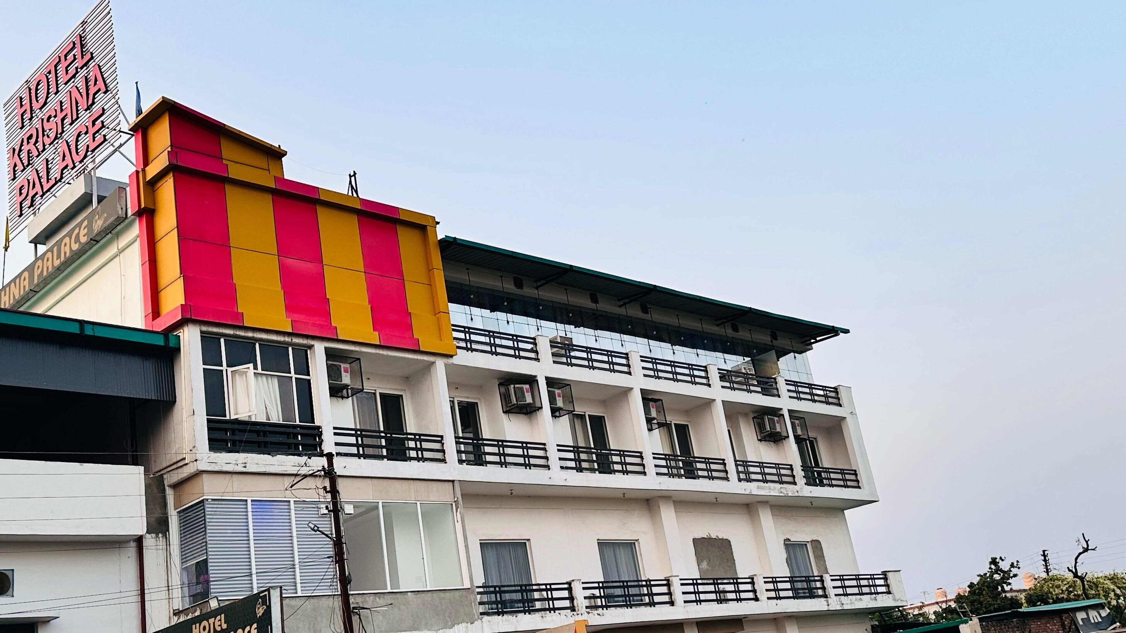 Un hotel a più piani con un cartello ben visibile che riporta "Hotel Krishna Palace".