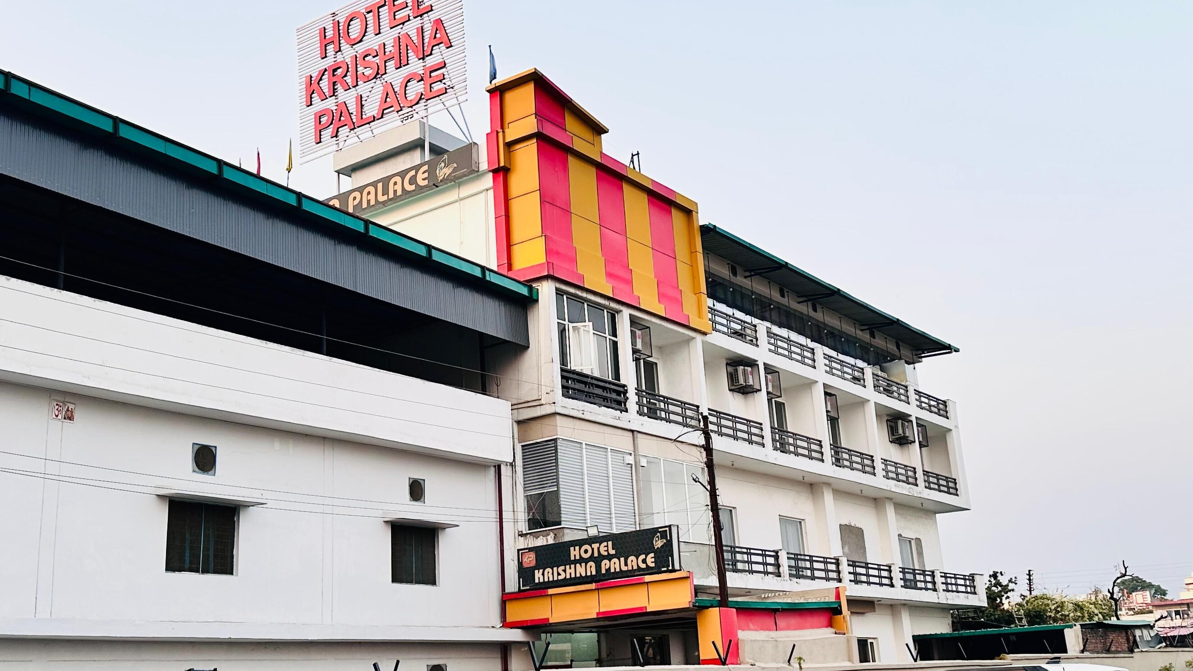 A multi-story hotel building with a prominent sign reading "HOTEL KRISHNA PALACE."