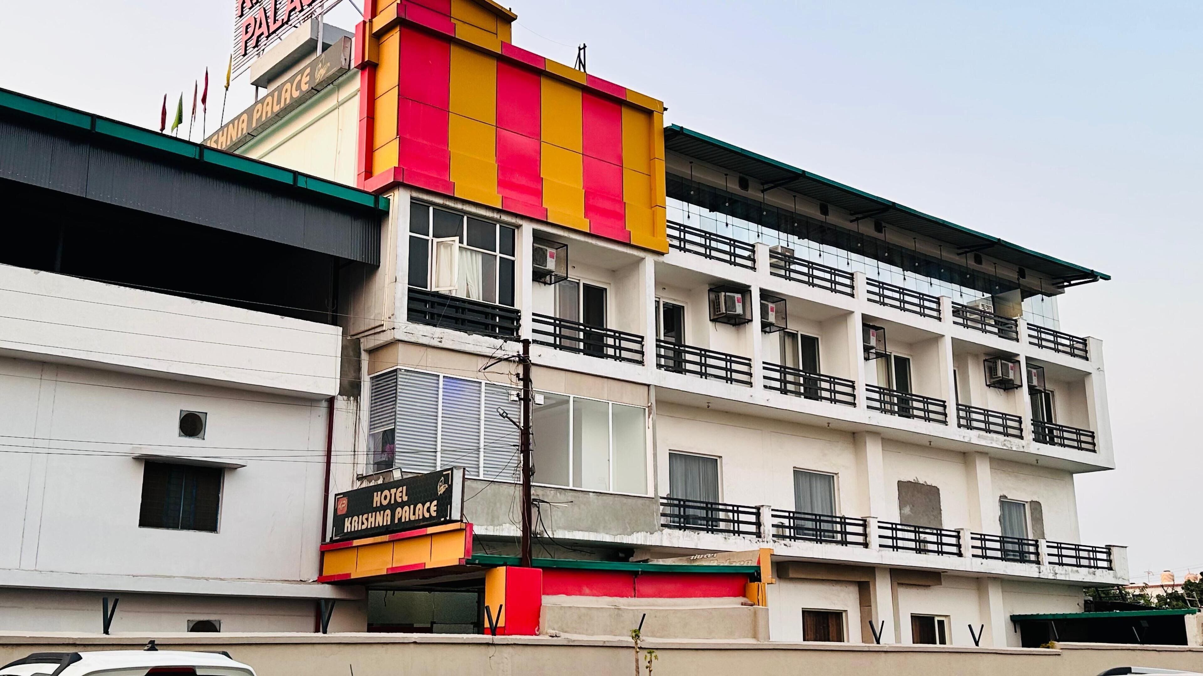 A multi-story building with a sign indicating it is the Krishna Palace Hotel.