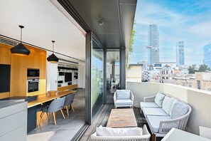 Een modern appartement met keuken, eethoek en balkon met uitzicht op de stad.
