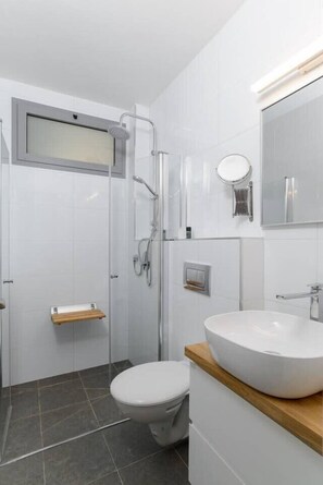 Un baño moderno con ducha, inodoro y lavamanos.