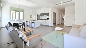 Un appartement moderne comprenant un coin repas, une cuisine et un salon.