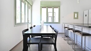 Une cuisine moderne avec une table et des chaises, de grandes fenêtres et un coin bar.