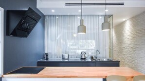 A modern kitchen with a central island, stainless steel appliances, and pendant lighting.