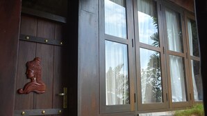 A wooden door with a decorative relief and a window with multiple panes.