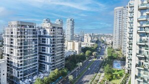 A high-rise residential building with multiple balconies, a clear view of the street below, and a modern architectural design.