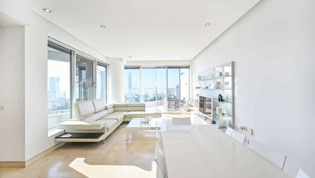 A modern living room with a sofa, coffee table, and a glass cabinet.