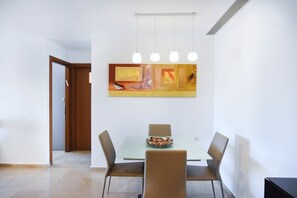 Un coin repas avec une table, des chaises et un tableau accroché au mur.