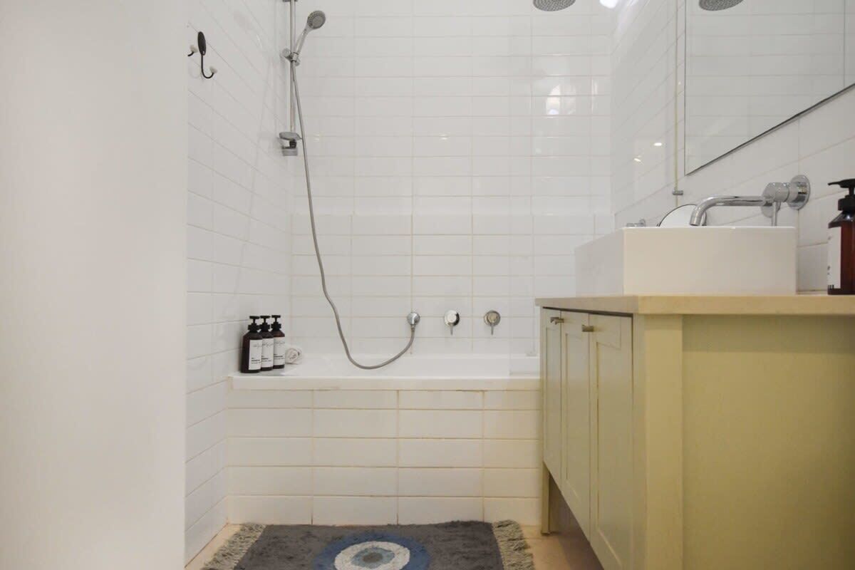 Un bagno con vasca, doccia e lavandino.