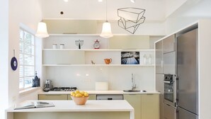 A modern kitchen with a central island, stainless steel appliances, and pendant lighting. - Spacious 3BR at Mapu st by HolyGuest (Tel Aviv)