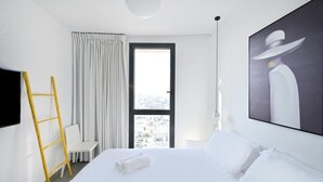 A hotel room with a bed, a window with curtains, a painting on the wall, and a yellow ladder.