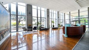 Un hall d’entrée spacieux, doté d’un plancher en bois, de grandes fenêtres et d’un comptoir de réception.