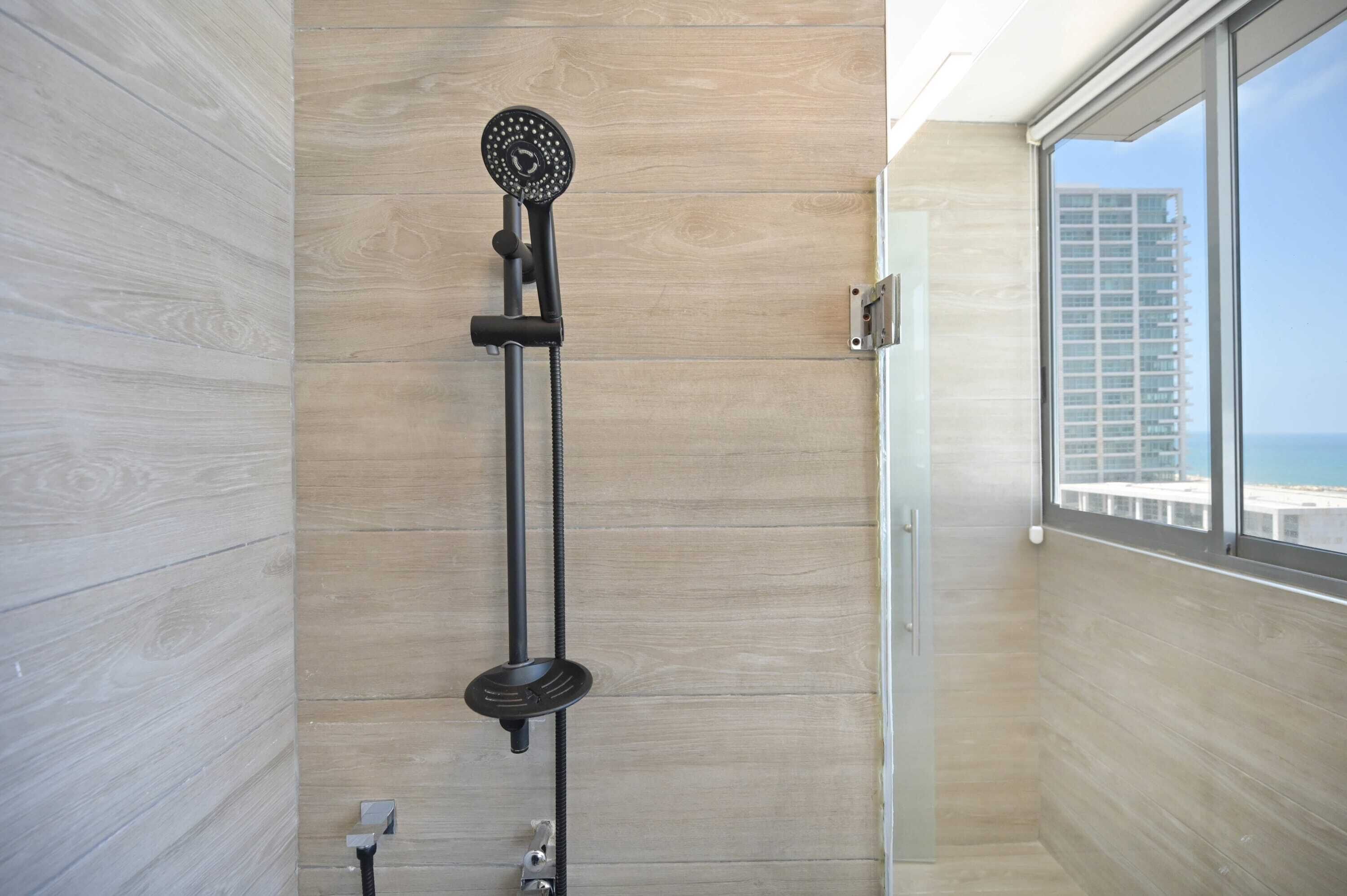 Ein modernes Badezimmer mit bodengalerischer Dusche, Holzwänden und Blick auf einen Hochhaus.