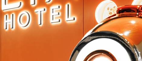 A neon sign for "Lia Hotel" with a metallic hand sculpture.