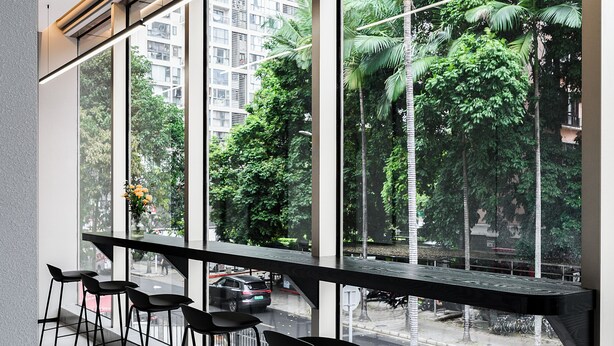 A modern interior with large windows, black chairs, and a view of a cityscape with greenery. - Liya Hotel Futian Free Trade Zonam (Shenzhen)