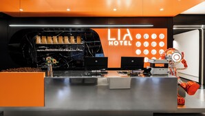 A modern hotel reception desk with a marble counter, a digital display, and a robot. - Liya Hotel Futian Free Trade Zonam (Shenzhen)