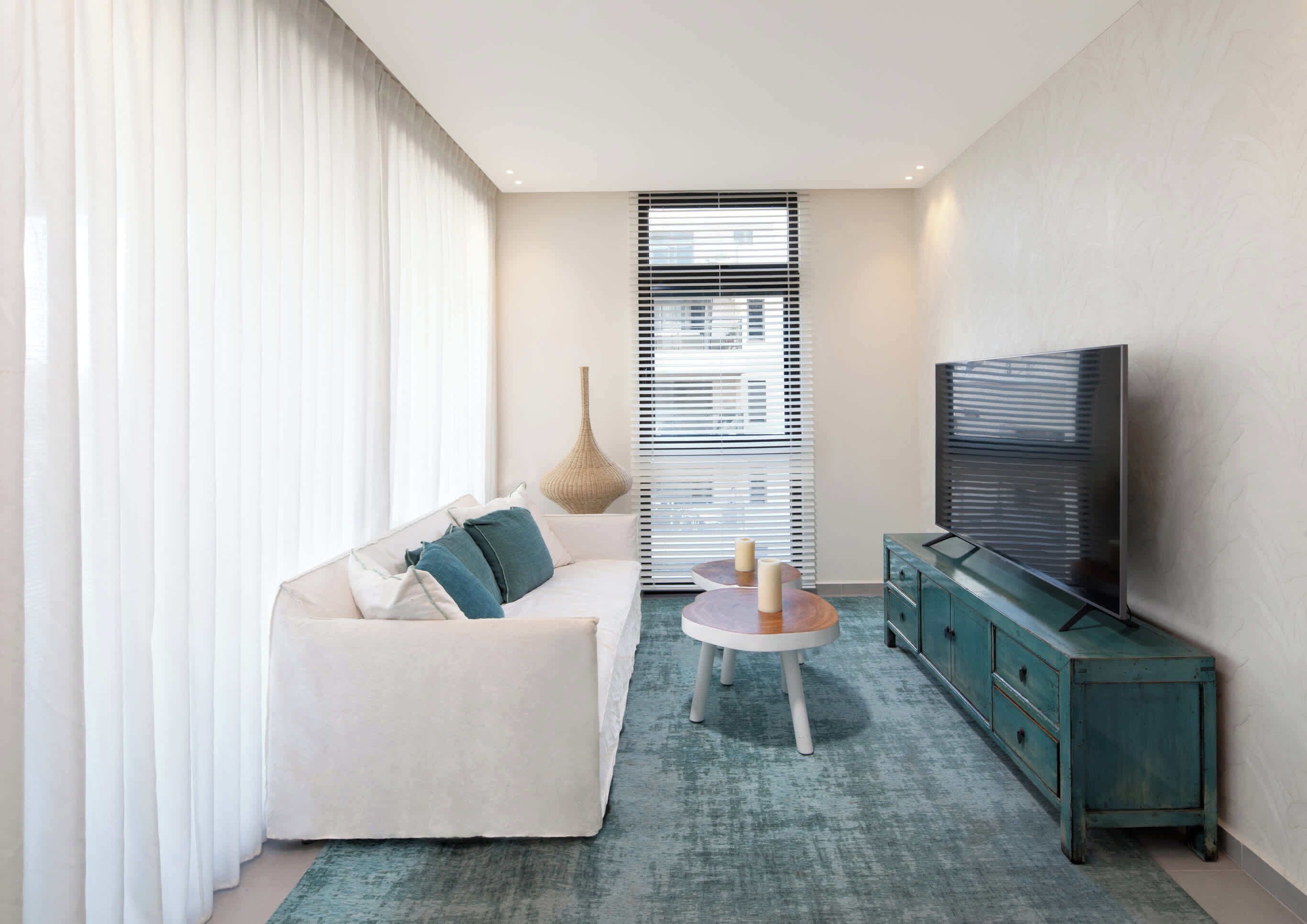 A modern living room with a sofa, a coffee table, a TV, and a cabinet.
