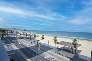 A coastal road with a beach and palm trees. - Luxurious Beach Front 1BR by HolyGuest (Tel Aviv)