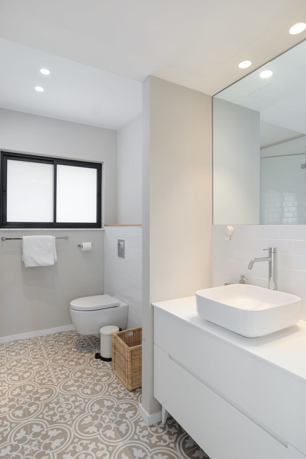 A modern bathroom with a toilet, bidet, and a large mirror.