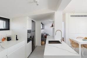 Een moderne keuken met witte kasten, een ingebouwde oven en een spoelbak.