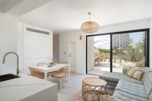 Una cocina moderna con comedor, sofá y vistas al exterior.
