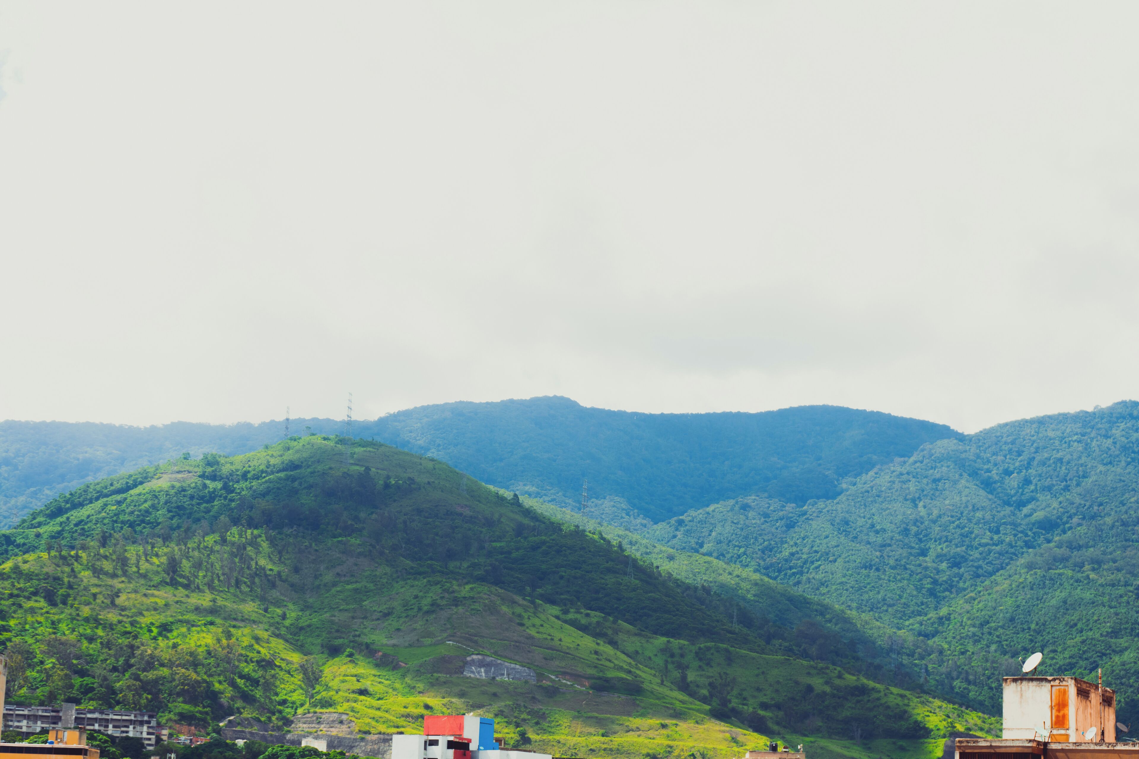 A mountainous landscape with buildings in the foreground.