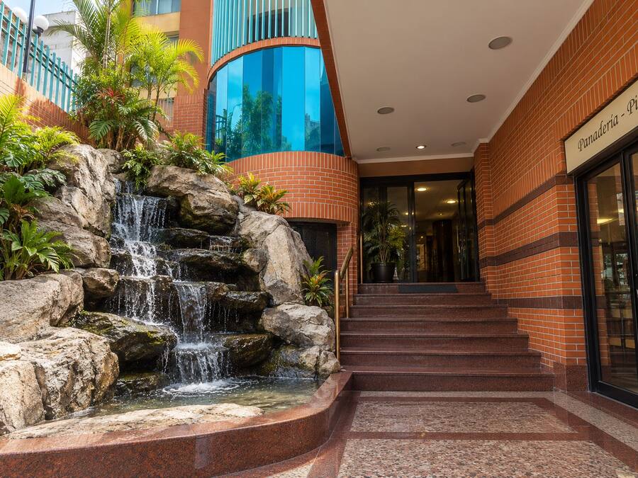Ein Gebäudeeingang mit Ziegelverkleidung, einem Wasserfall und einer Treppe zum Eingang.
