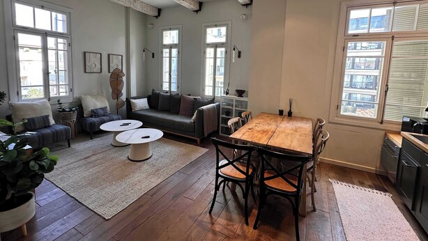 Un amplio salón con una mesa de comedor de madera, dos sofás y una mesa de centro.