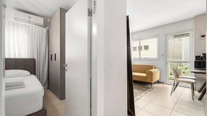Habitación de hotel con cama, armario, escritorio y silla, y vistas al exterior.