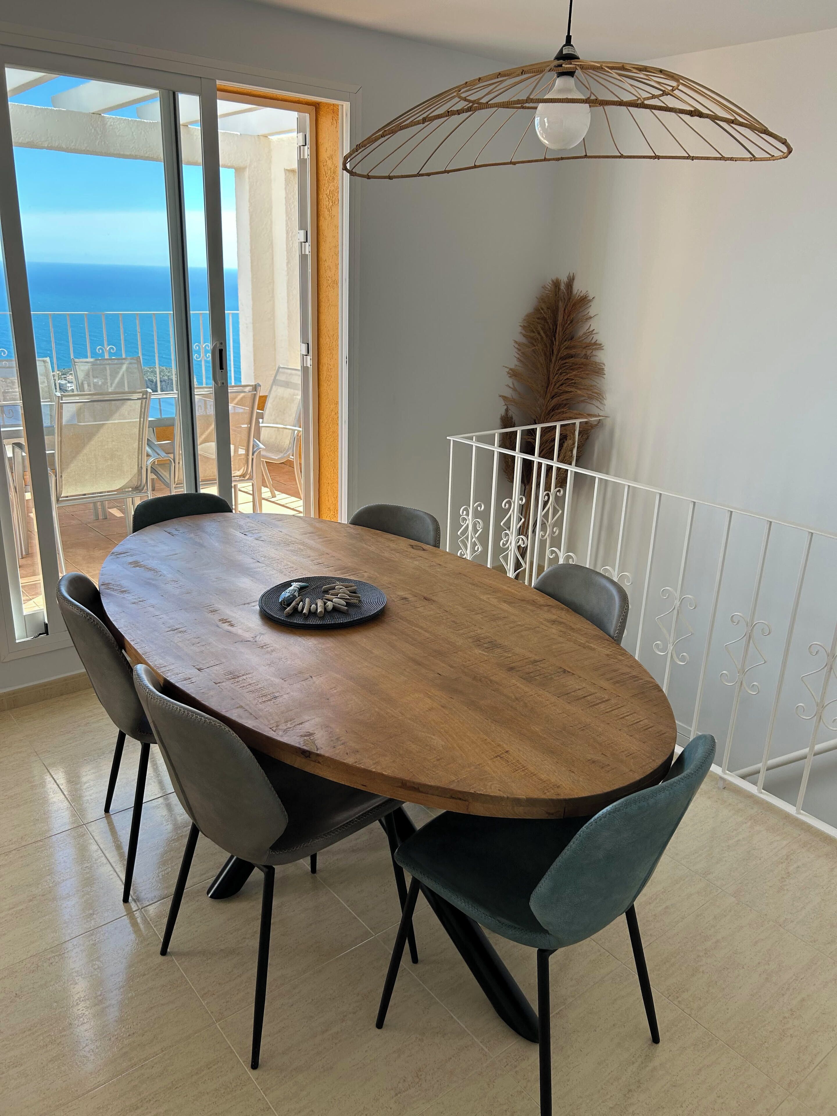 Un espace repas comprenant une table en bois, des chaises et un luminaire suspendu.
