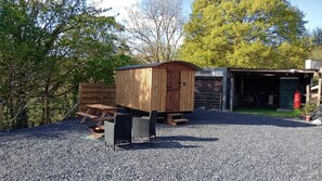 A gravel-covered area with a wooden shed, a picnic table, and a covered outdoor seating area. - Llandovery - Lodge - Sleeps 2 - Parking - Hot Tub (Llandovery)