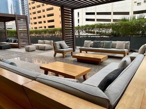 Un espace extérieur aménagé avec des canapés, des fauteuils et une table basse.