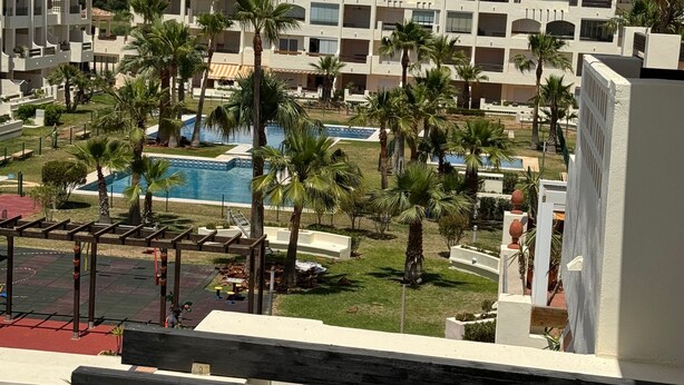 Un resort con varias edificaciones, piscina y palmeras.