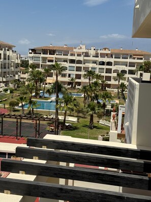 Ein Resort mit mehreren Gebäuden, einem Schwimmbad und Palmen.