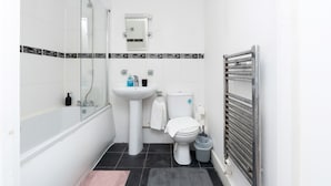A bathroom with a bathtub, sink, toilet, and a glass shower enclosure.