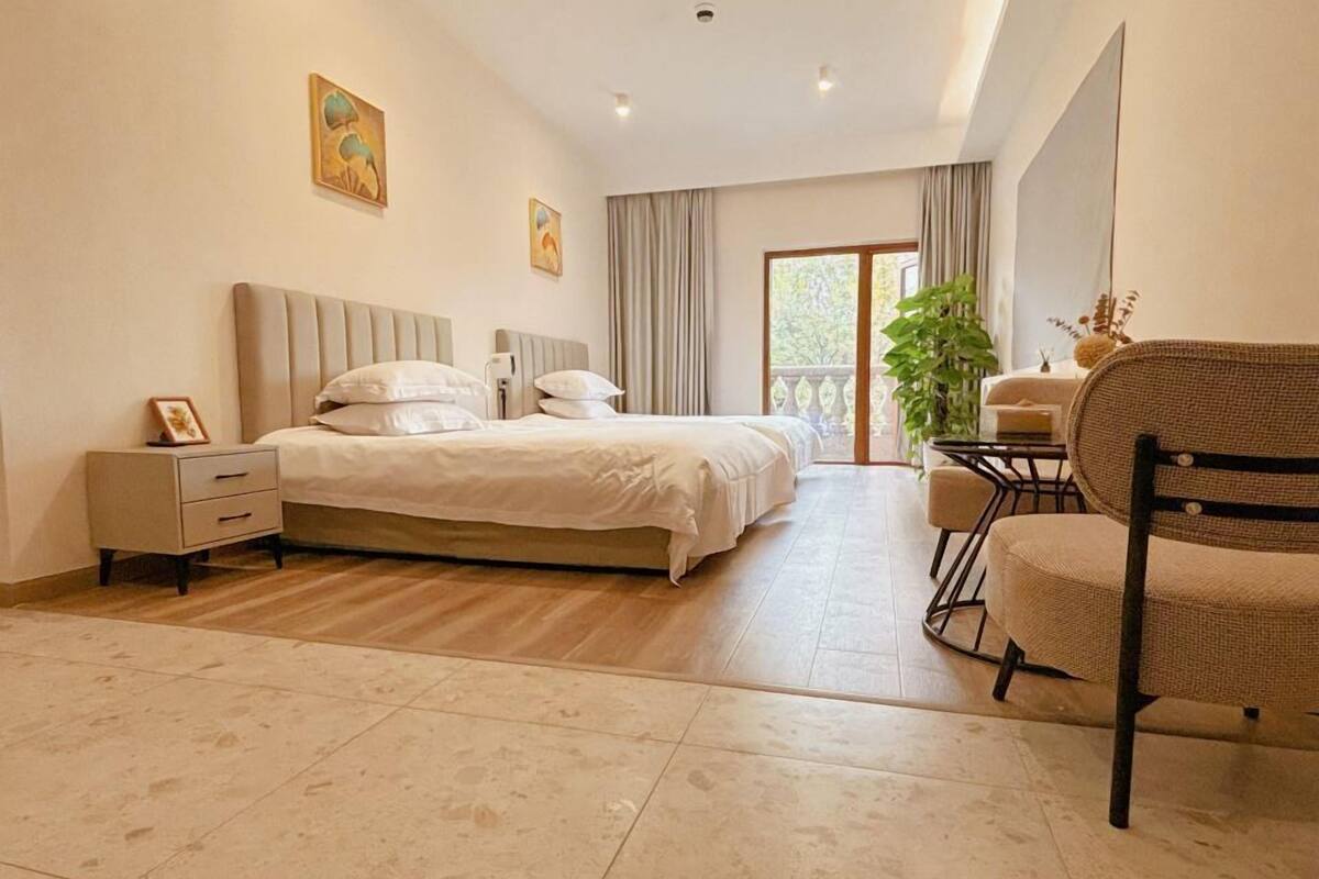 Un dormitorio con cama, mesitas de noche, una silla y un escritorio.