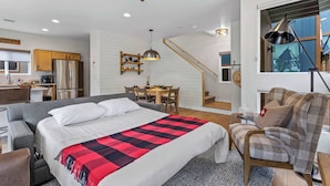 Een moderne hotelkamer met een groot bed, een bureau, een stoel, een eettafel en een trap.