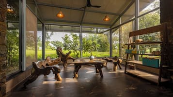 Amplia habitación con un gran ventanal, muebles de madera y un ventilador de techo.