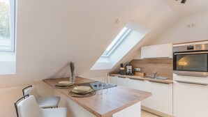 Una cocina moderna con tragaluz, encimera de madera y electrodomésticos de acero inoxidable.