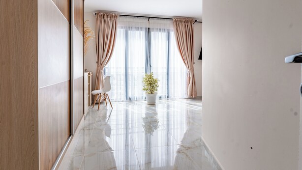 A modern hotel room with a large window, a potted plant, and a sleek marble floor. - TERANGA ROOF TOP Exceptional seaside apartment (Dakar)