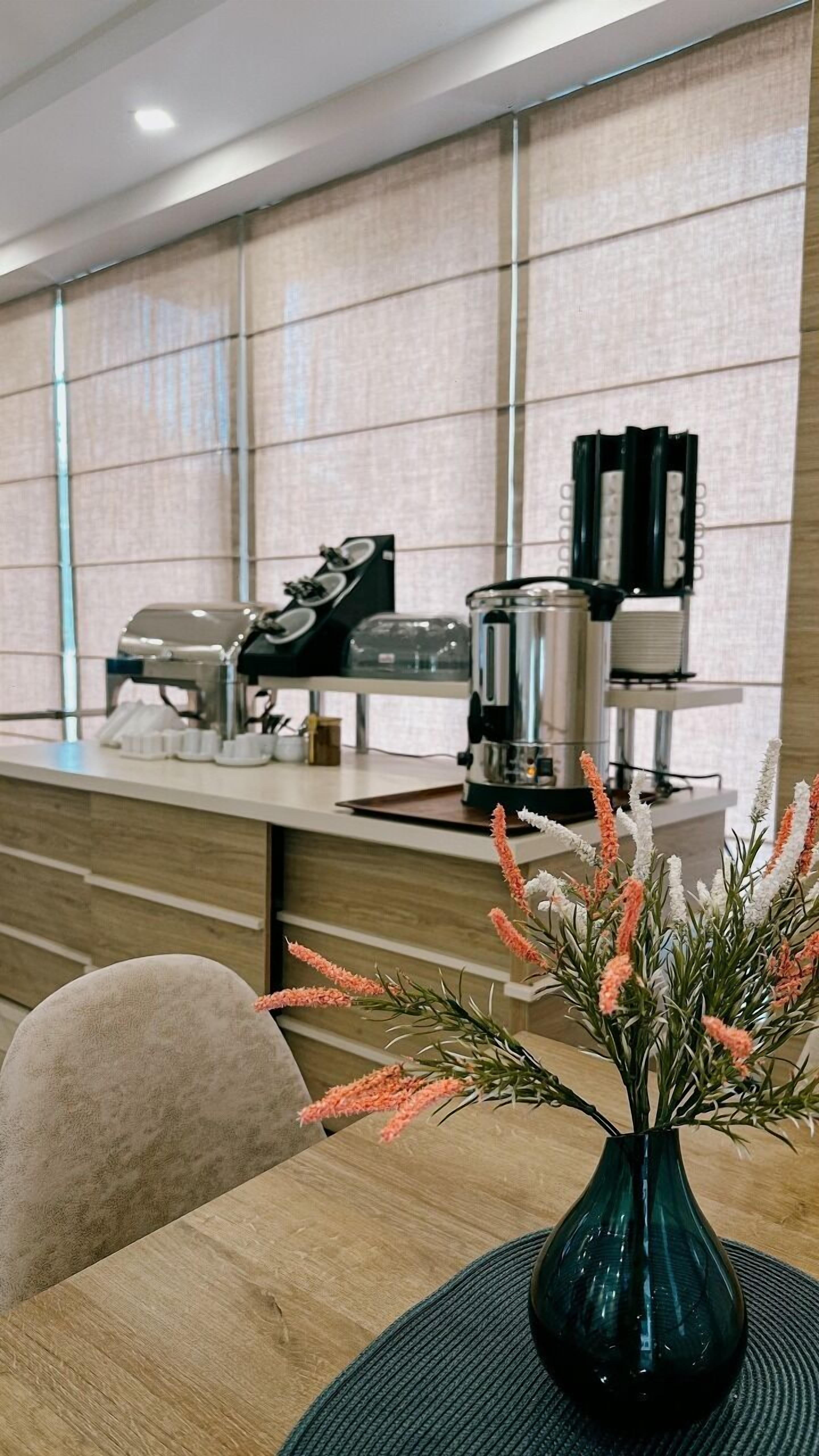 Una cocina moderna con una cafetera, un hervidor y una prensa francesa en la encimera.